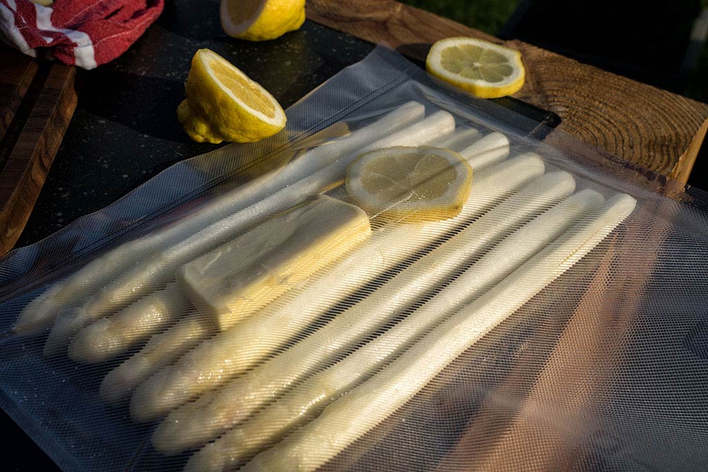 In zwei Vakuumbeuteln jeweils 8 Stangen Spargel mit einem halben TL Salz,
einem halben TL Zucker, zwei EL Butter und einer Scheibe Zitrone einschweißen.